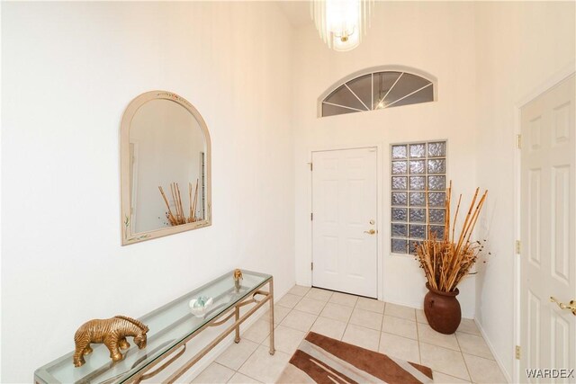 foyer entrance featuring light tile patterned floors and a towering ceiling