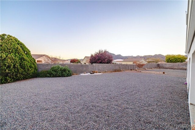 yard at dusk with a fenced backyard