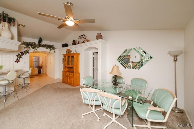 dining room featuring arched walkways, visible vents, a ceiling fan, vaulted ceiling, and carpet