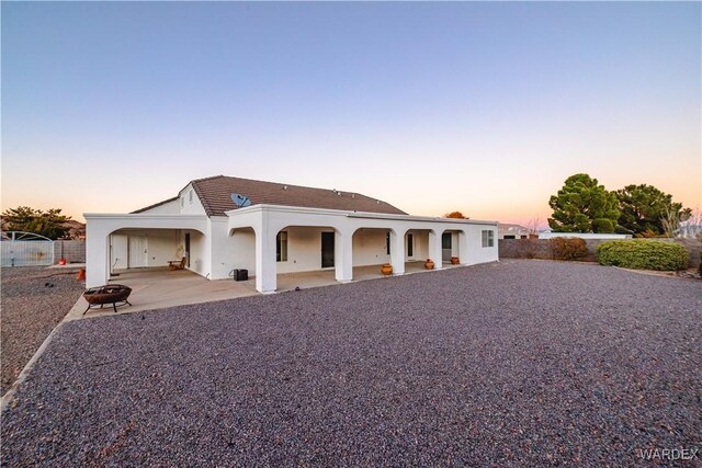 mediterranean / spanish-style house with a patio area, fence, and stucco siding