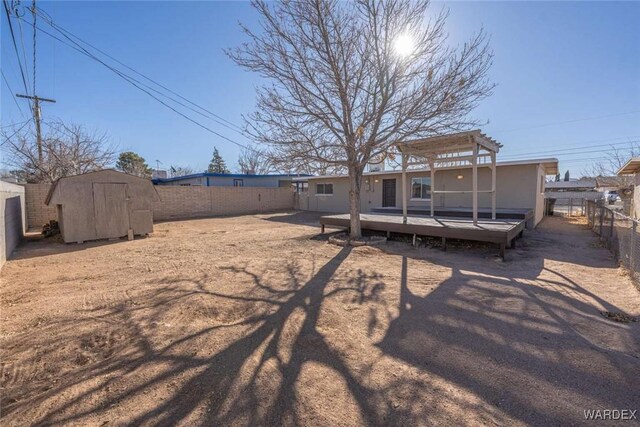 back of house featuring a storage shed, a fenced backyard, a pergola, and a wooden deck