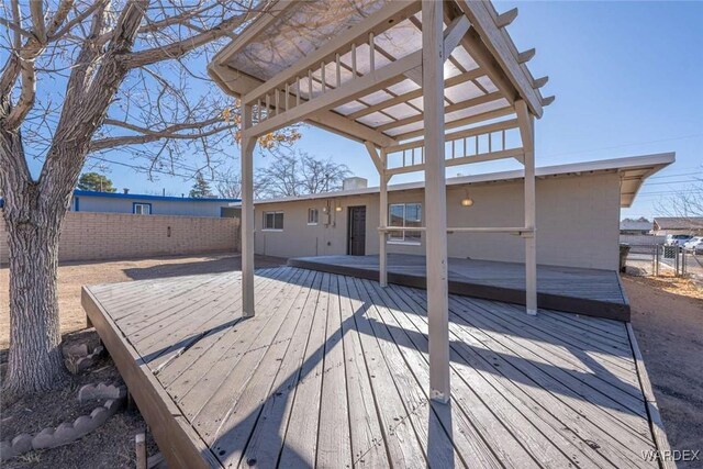 deck featuring fence and a pergola