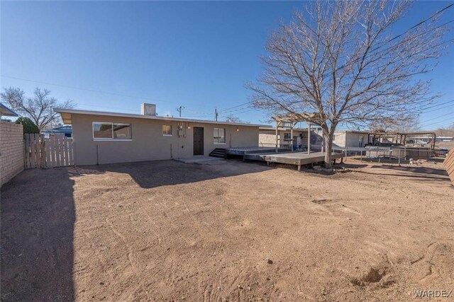 rear view of house with a deck and a fenced backyard