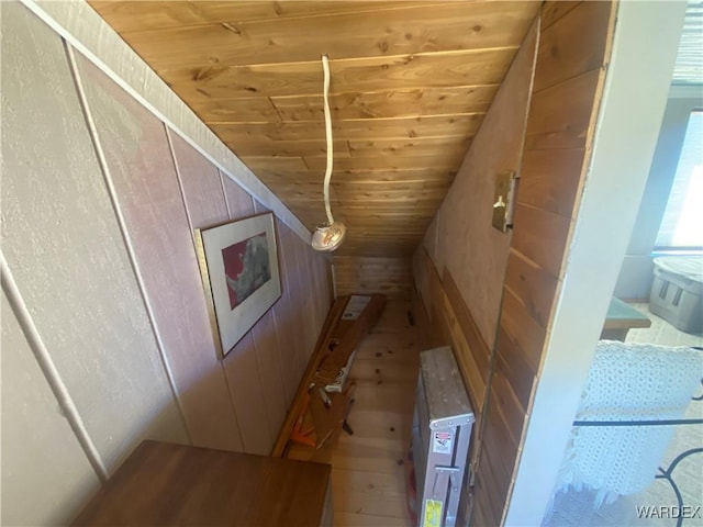 interior space featuring a sauna, wood ceiling, wooden walls, and wood finished floors