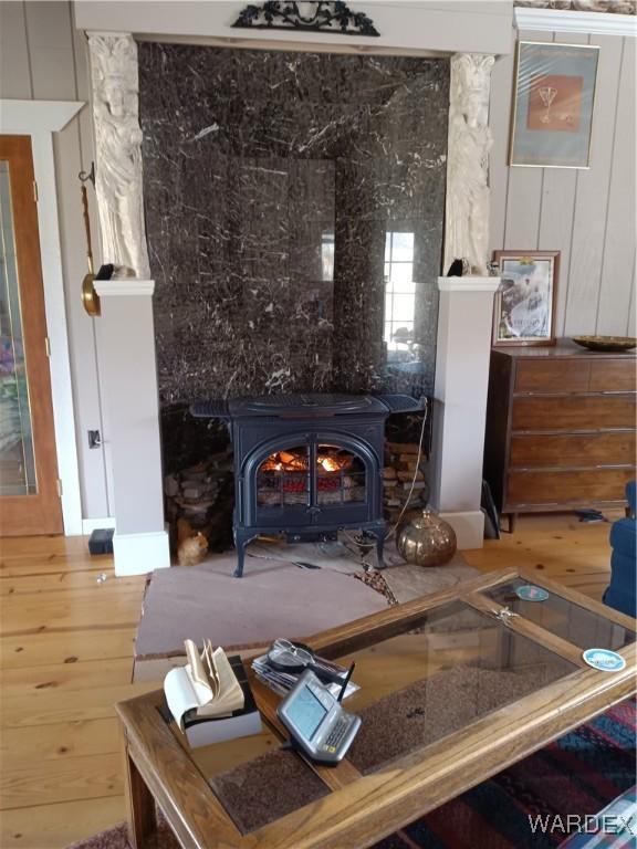 interior space with a wood stove and wood finished floors