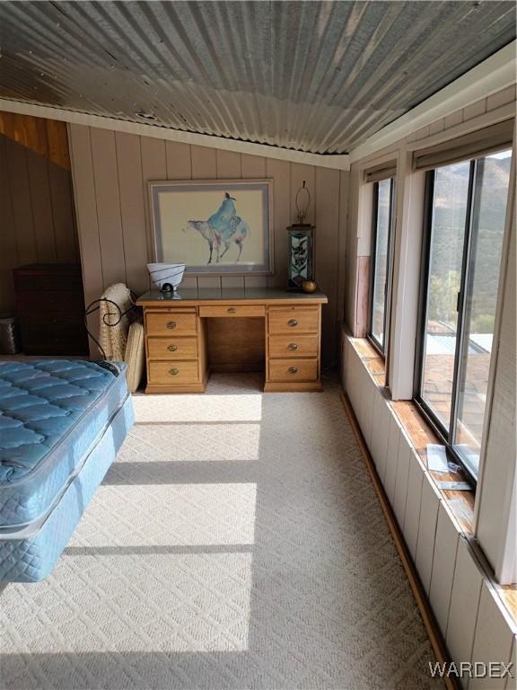 bedroom featuring wood ceiling, wood walls, access to outside, and light carpet