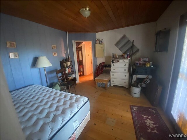 bedroom with light wood-style flooring and wood ceiling