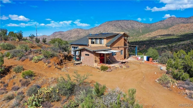 exterior space with a mountain view, driveway, and stucco siding