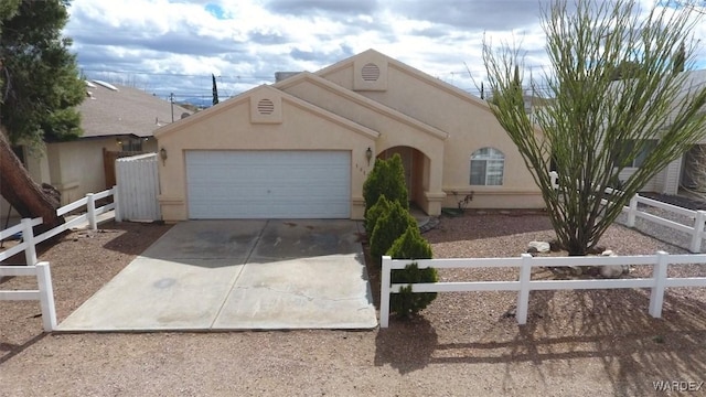 view of front of home with a garage, fence, driveway, and stucco siding