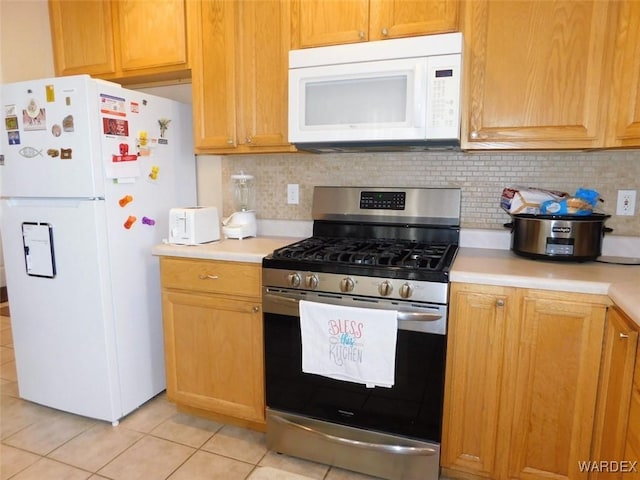 kitchen featuring tasteful backsplash, white appliances, light countertops, and light tile patterned floors