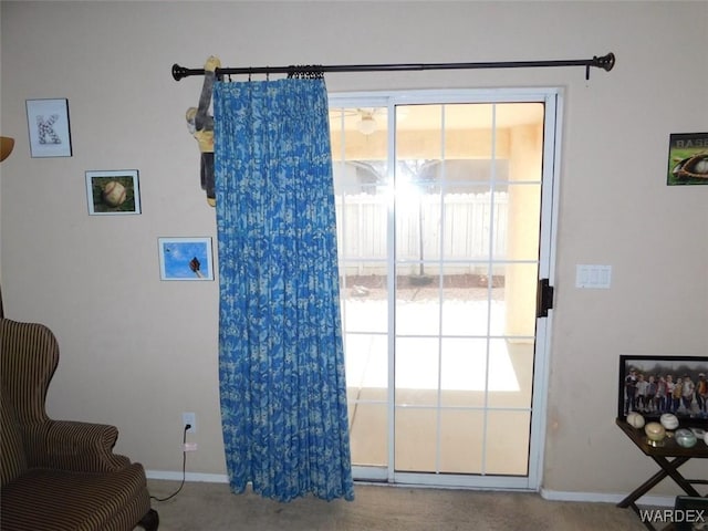 doorway to outside featuring carpet floors and baseboards