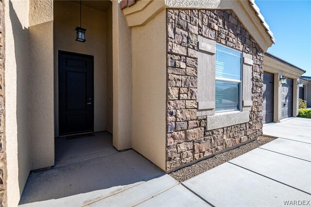 property entrance featuring stone siding and stucco siding