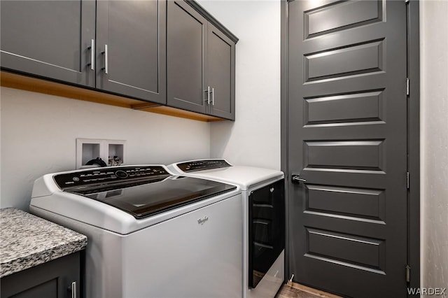 clothes washing area with washer and clothes dryer and cabinet space