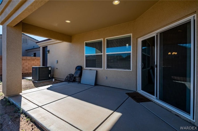 view of patio featuring central AC unit and fence