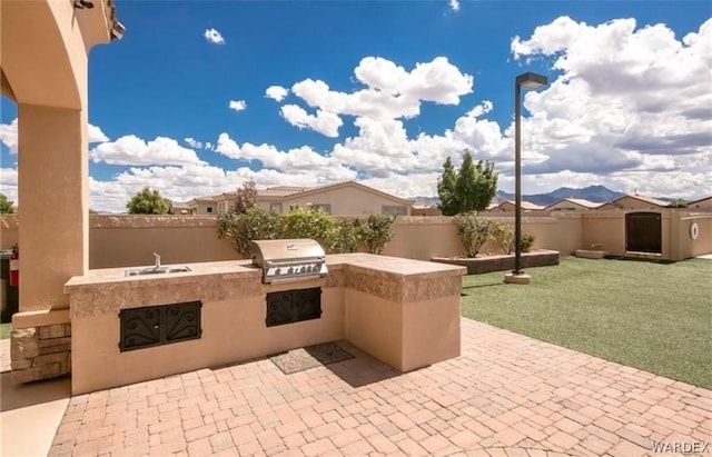 view of patio / terrace with a fenced backyard, a grill, a sink, and area for grilling