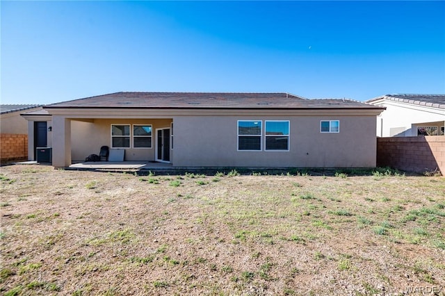 rear view of house featuring fence, a patio, and stucco siding