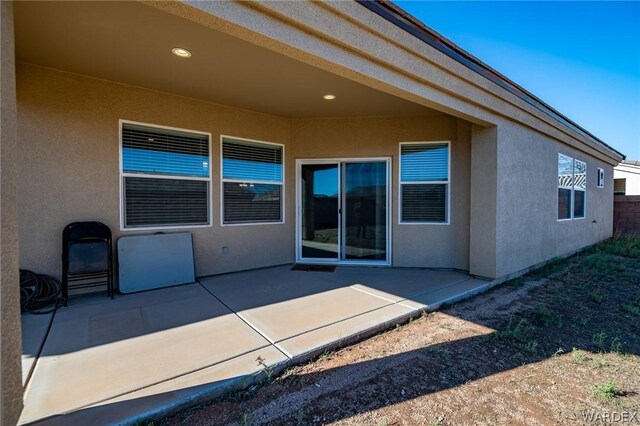 back of house with a patio area, fence, and stucco siding