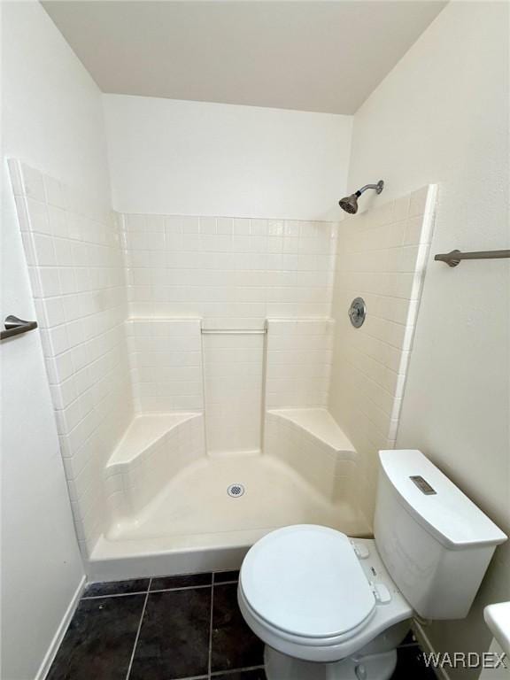 full bathroom with a shower stall, toilet, and tile patterned floors