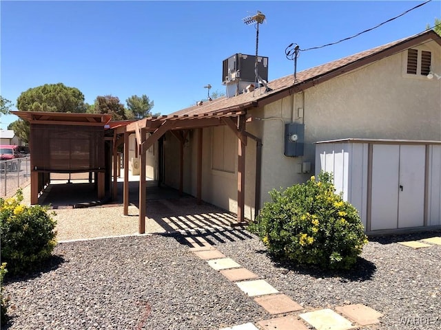 rear view of property with central AC unit and stucco siding