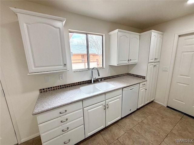 kitchen with baseboards, white cabinets, dishwasher, a sink, and light tile patterned flooring