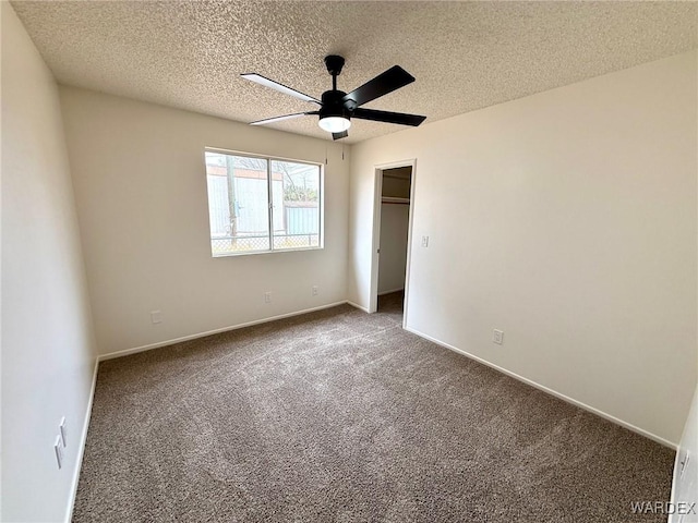 unfurnished bedroom featuring a textured ceiling, baseboards, and carpet flooring