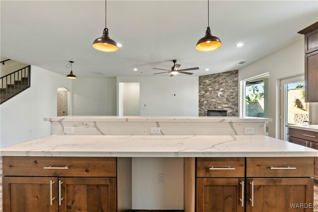 10726 S River Terrace Dr, Mohave Valley, AZ 86440 - kitchen featuring a stone fireplace, hanging light fixtures, recessed lighting, a ceiling fan, and open floor plan