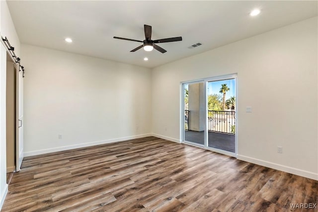 10726 S River Terrace Dr, Mohave Valley, AZ 86440 - spare room with a barn door, ceiling fan, wood finished floors, recessed lighting, and baseboards