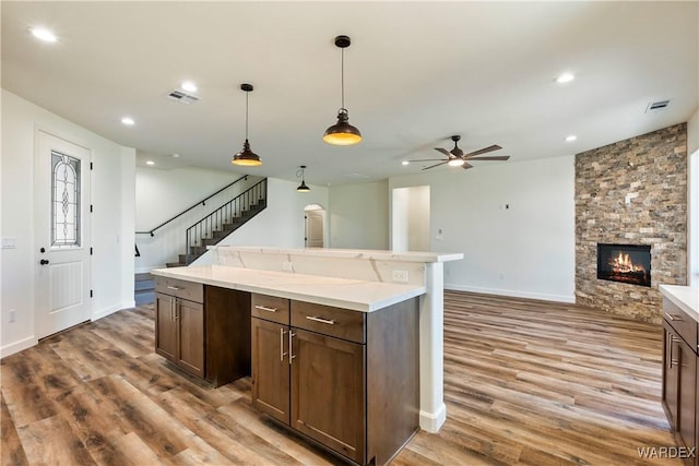 10726 S River Terrace Dr, Mohave Valley, AZ 86440 - kitchen featuring a ceiling fan, light wood finished floors, open floor plan, a stone fireplace, and light countertops
