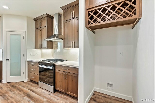 10726 S River Terrace Dr, Mohave Valley, AZ 86440 - kitchen featuring stainless steel gas stove, wall chimney exhaust hood, light wood-style floors, baseboards, and light countertops