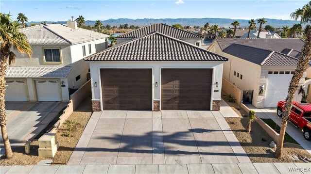 10726 S River Terrace Dr, Mohave Valley, AZ 86440 - view of front of house featuring driveway, stone siding, a mountain view, and a tiled roof