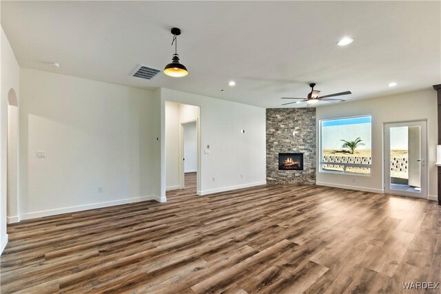 10726 S River Terrace Dr, Mohave Valley, AZ 86440 - unfurnished living room with dark wood-style flooring, ceiling fan, baseboards, a stone fireplace, and recessed lighting