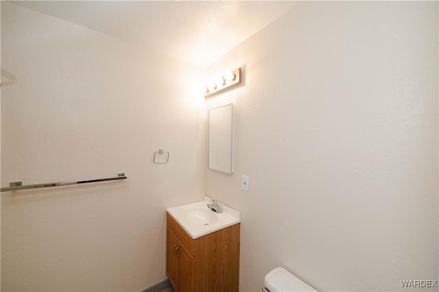 half bathroom with toilet and vanity