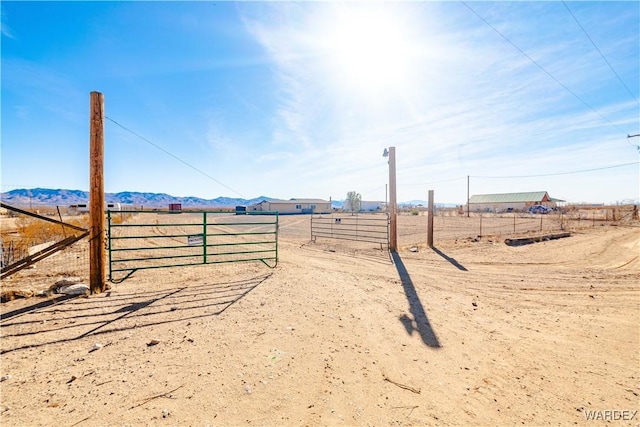 view of yard with fence, a mountain view, and a rural view