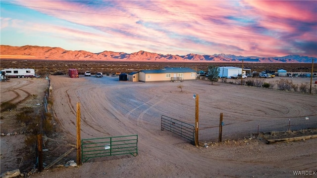 property view of water featuring an enclosed area, a mountain view, and fence