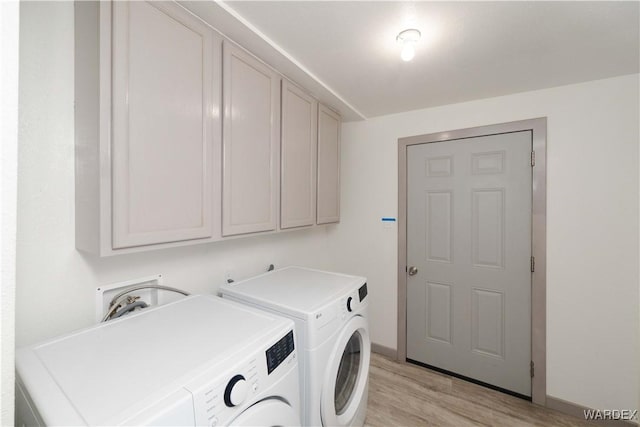 washroom with separate washer and dryer, cabinet space, and light wood-style floors