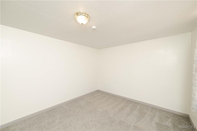 empty room with light carpet and baseboards