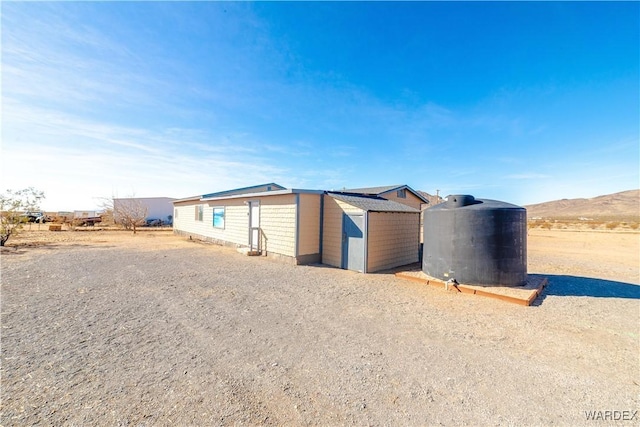 view of front of home with a storage unit and a mountain view