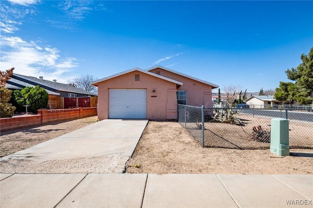 view of front facade with driveway, fence, and stucco siding