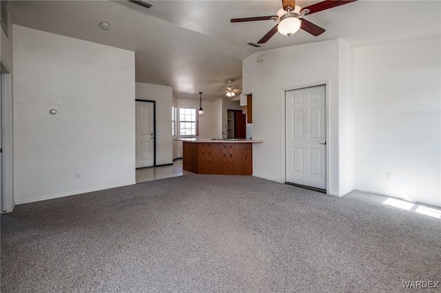 unfurnished living room with lofted ceiling, ceiling fan, a sink, and light colored carpet