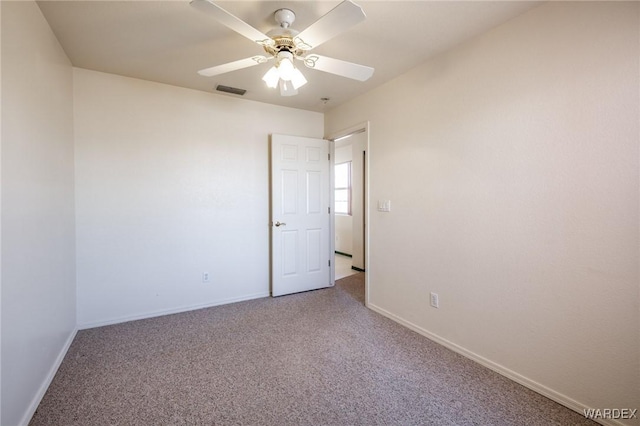 spare room featuring baseboards, carpet, visible vents, and a ceiling fan