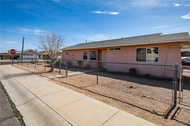 single story home with a fenced front yard, a gate, and stucco siding