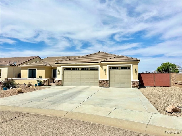 view of front of house with stucco siding, fence, a garage, driveway, and stone siding