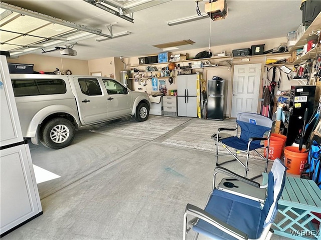 garage featuring a garage door opener and freestanding refrigerator