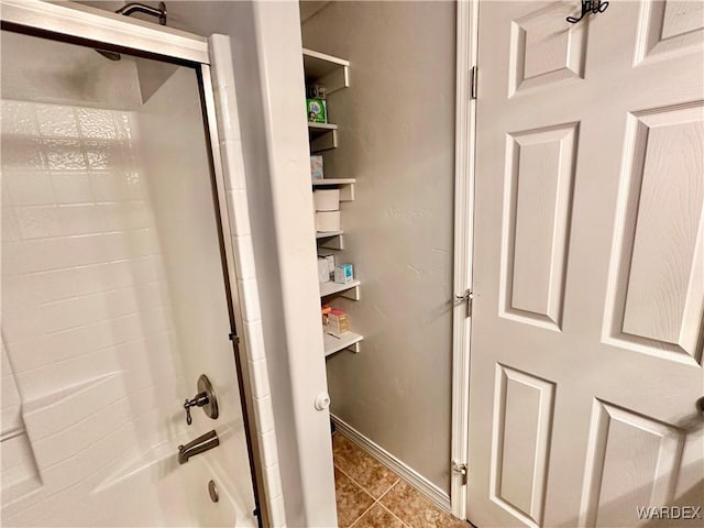 interior space featuring tile patterned floors, baseboards, and shower / washtub combination