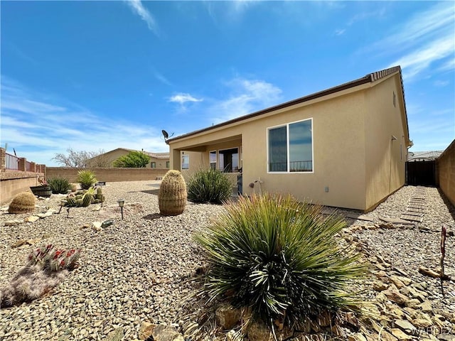 view of side of home featuring stucco siding and a fenced backyard