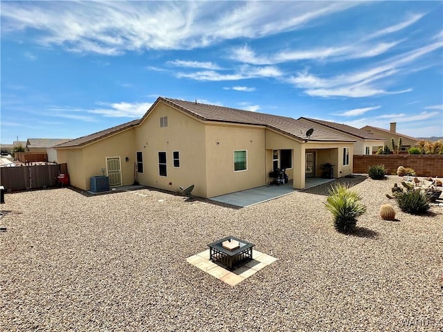 rear view of property featuring stucco siding, fence, and cooling unit