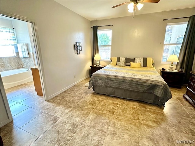 bedroom featuring light tile patterned floors, ensuite bathroom, ceiling fan, and baseboards