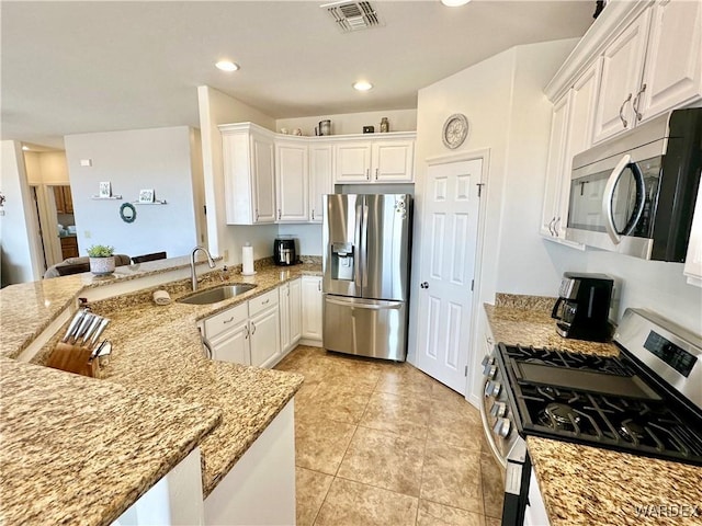 kitchen with a sink, white cabinetry, stainless steel appliances, and visible vents