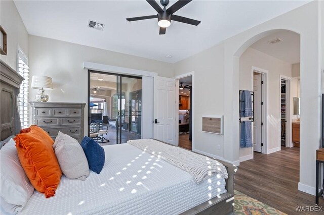 bedroom with access to outside, visible vents, arched walkways, and dark wood finished floors