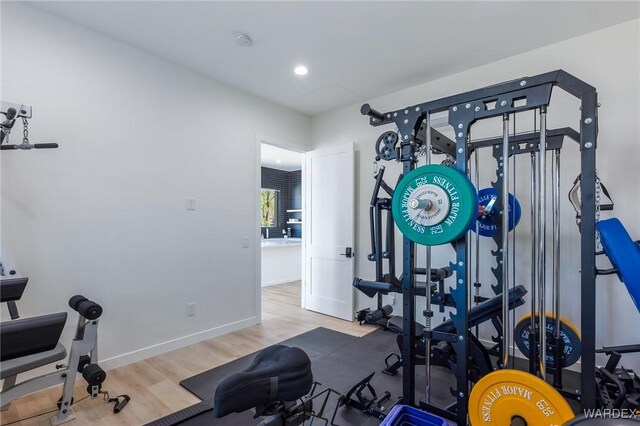 workout room with baseboards and wood finished floors